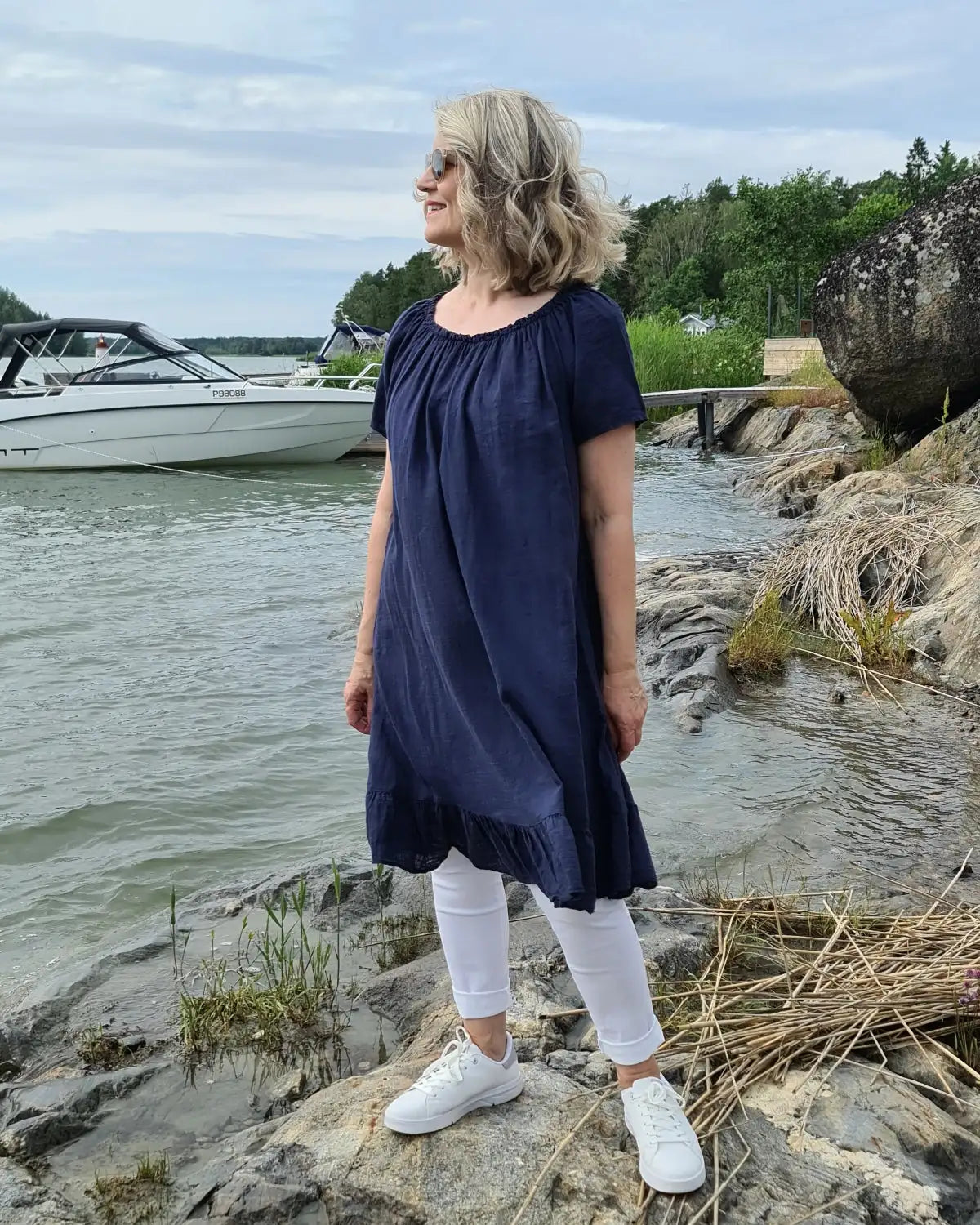 Tummansininen pellavamekko, jossa poimuttu pääntie ja röyhelöreunus
